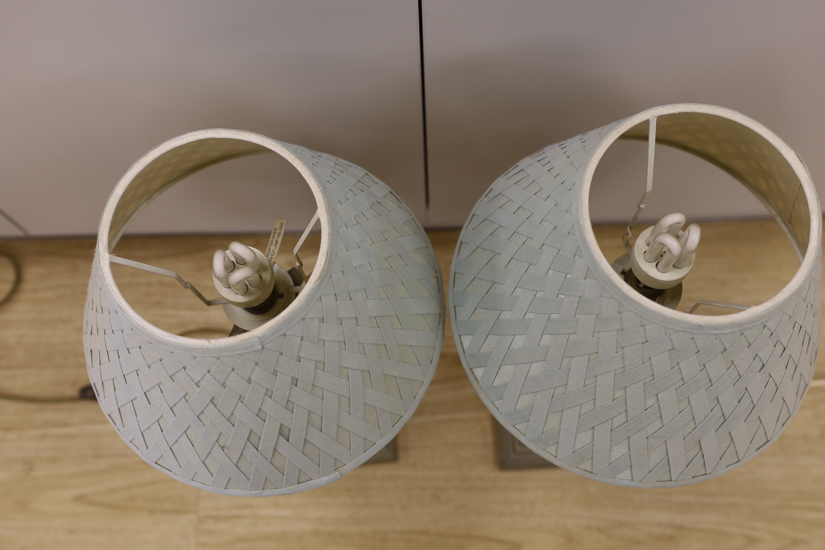 A pair of plated Corinthian column table lamps with green silk shades, 49.5cm tall